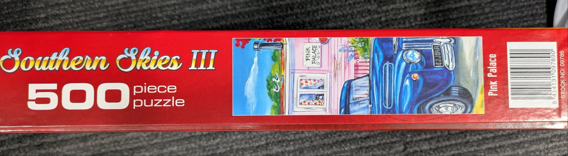 An illustration of a bright blue vintage car parked next to a charming pink building labeled Pink Palace.
