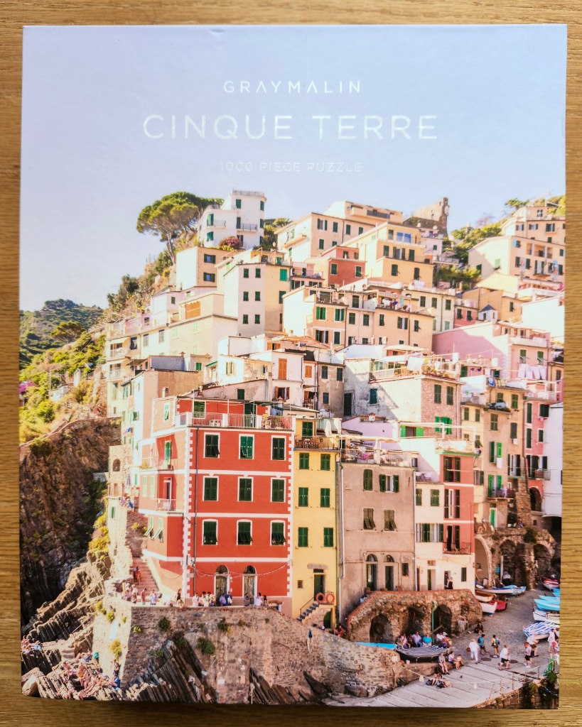 Aerial-style photograph of colorful hillside houses in Cinque Terre, Italy overlooking a small harbor.