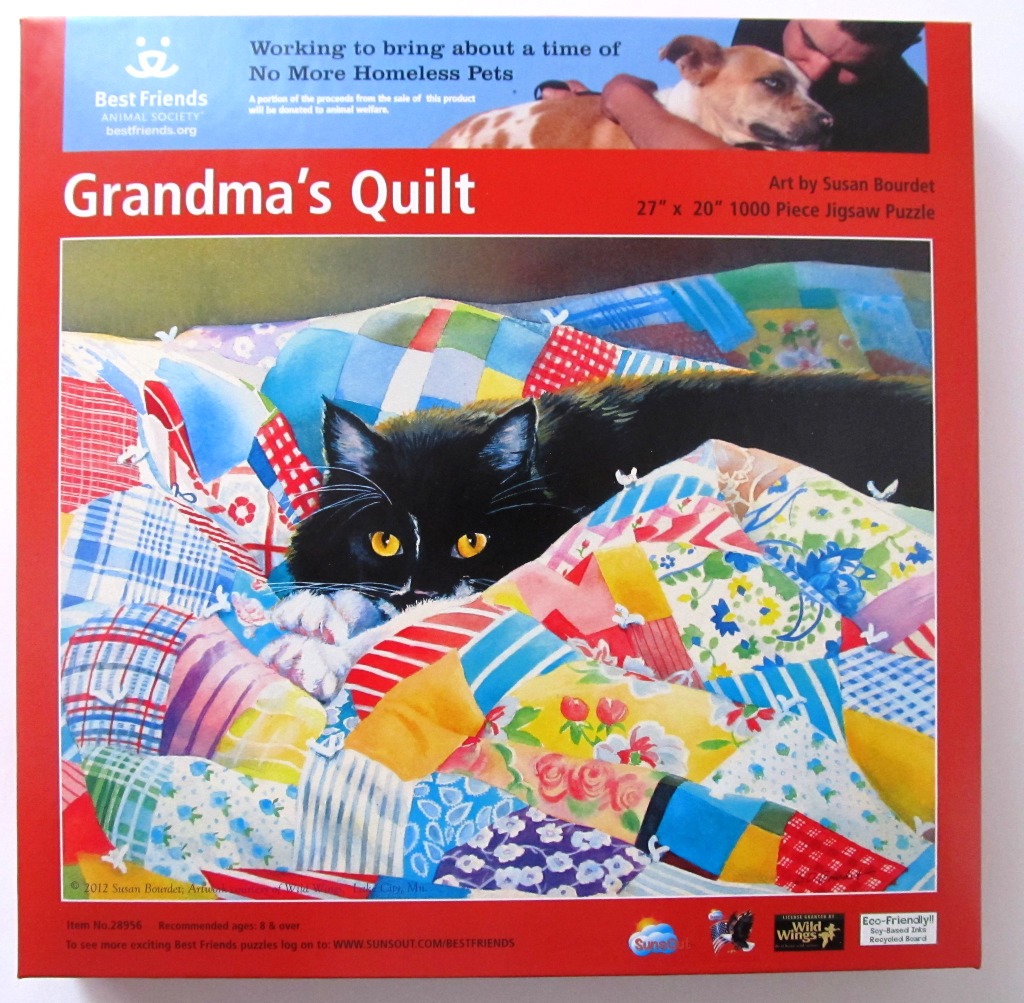 A black cat with bright yellow eyes resting on a colorful patchwork quilt.