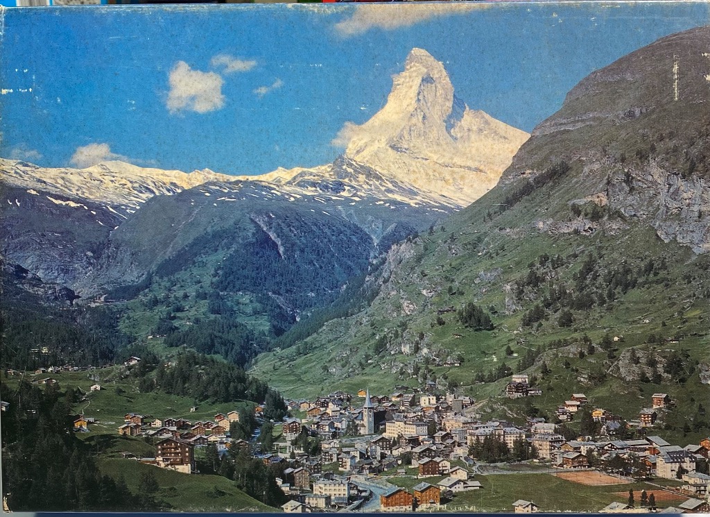 A panoramic landscape photograph of Zermatt nestled in a valley beneath the iconic Matterhorn mountain.