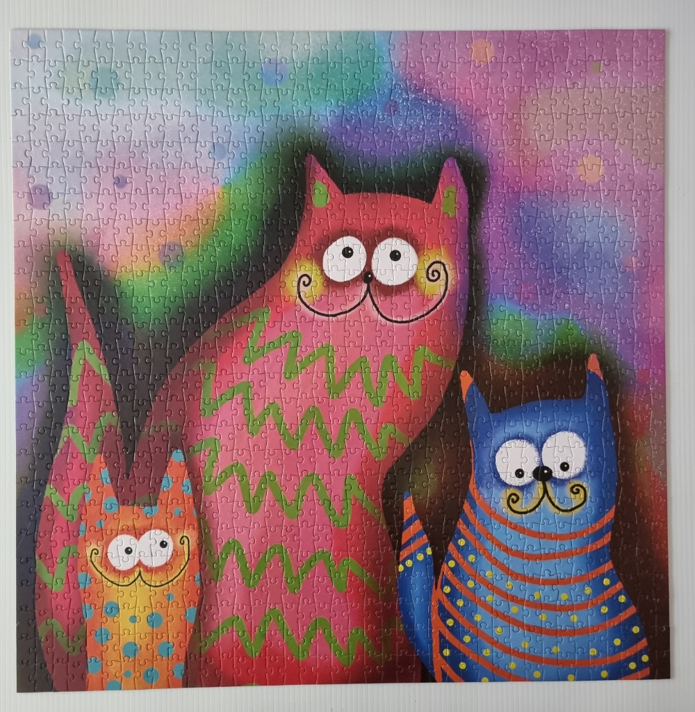 Whimsical illustration of three colorful cats against a gradient background