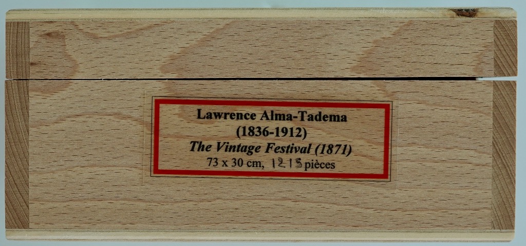 Text label for Lawrence Alma-Tadema painting, The Vintage Festival (1871), on a wooden surface.