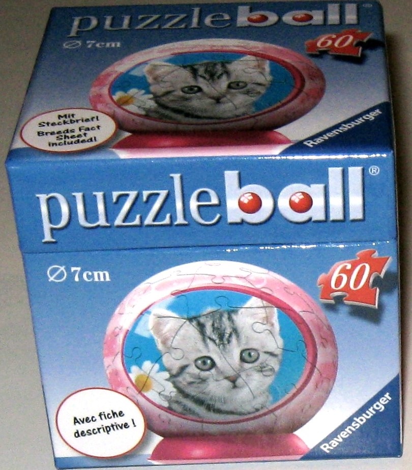 A spherical item featuring a portrait of a grey tabby kitten set against a blue background with a white flower.