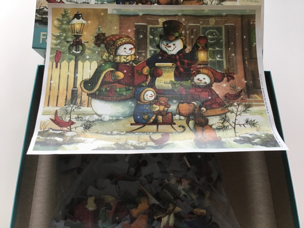 A festive illustration of a family of snowmen singing Christmas carols in the snow.