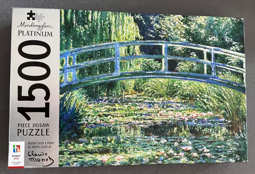 Impressionist painting of a green arched footbridge over a water lily pond.