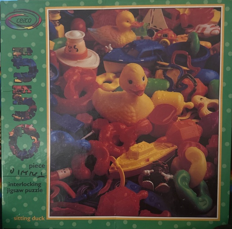 A cluttered pile of colorful plastic bath toys featuring two rubber ducks and various small boats.