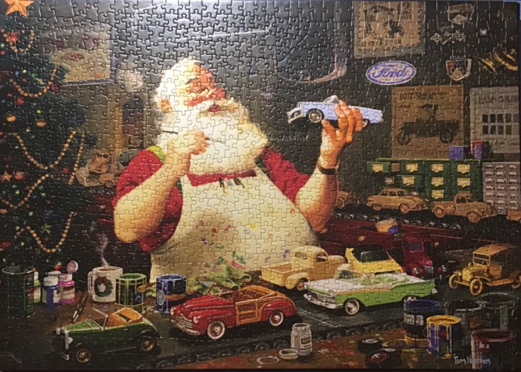 Santa Claus in his workshop painting a miniature classic car model surrounded by other antique toy cars.