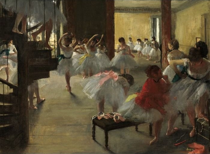 Ballerinas in white tutus gathering and preparing in a warm-toned dance studio