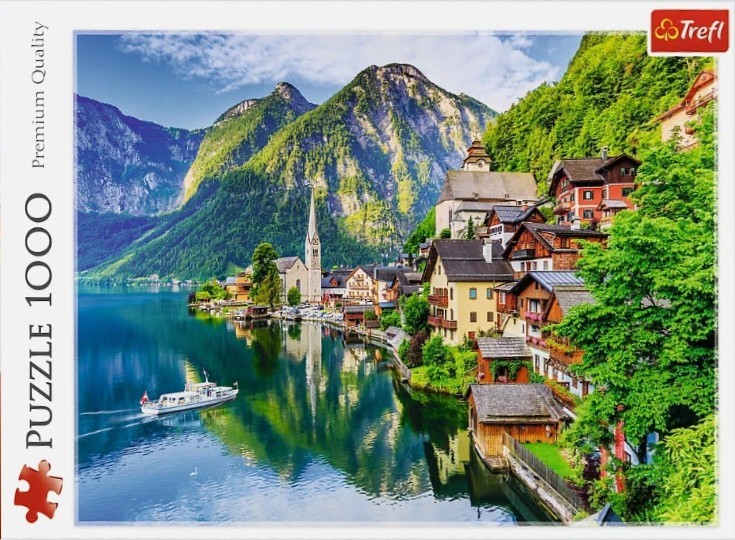 A scenic photograph of the village of Hallstatt, Austria, reflected in a calm blue lake beneath towering mountains.
