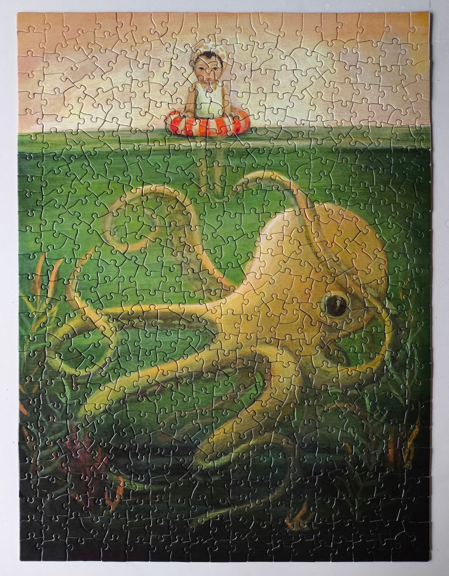 A young child floats in an orange life ring above a large, golden-yellow octopus swimming underwater.
