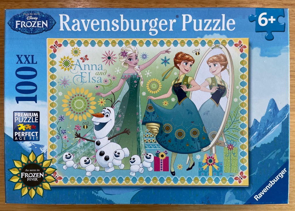 Elsa, Anna, and Olaf from Frozen Fever with sunflower patterns and a mirror against a green background.