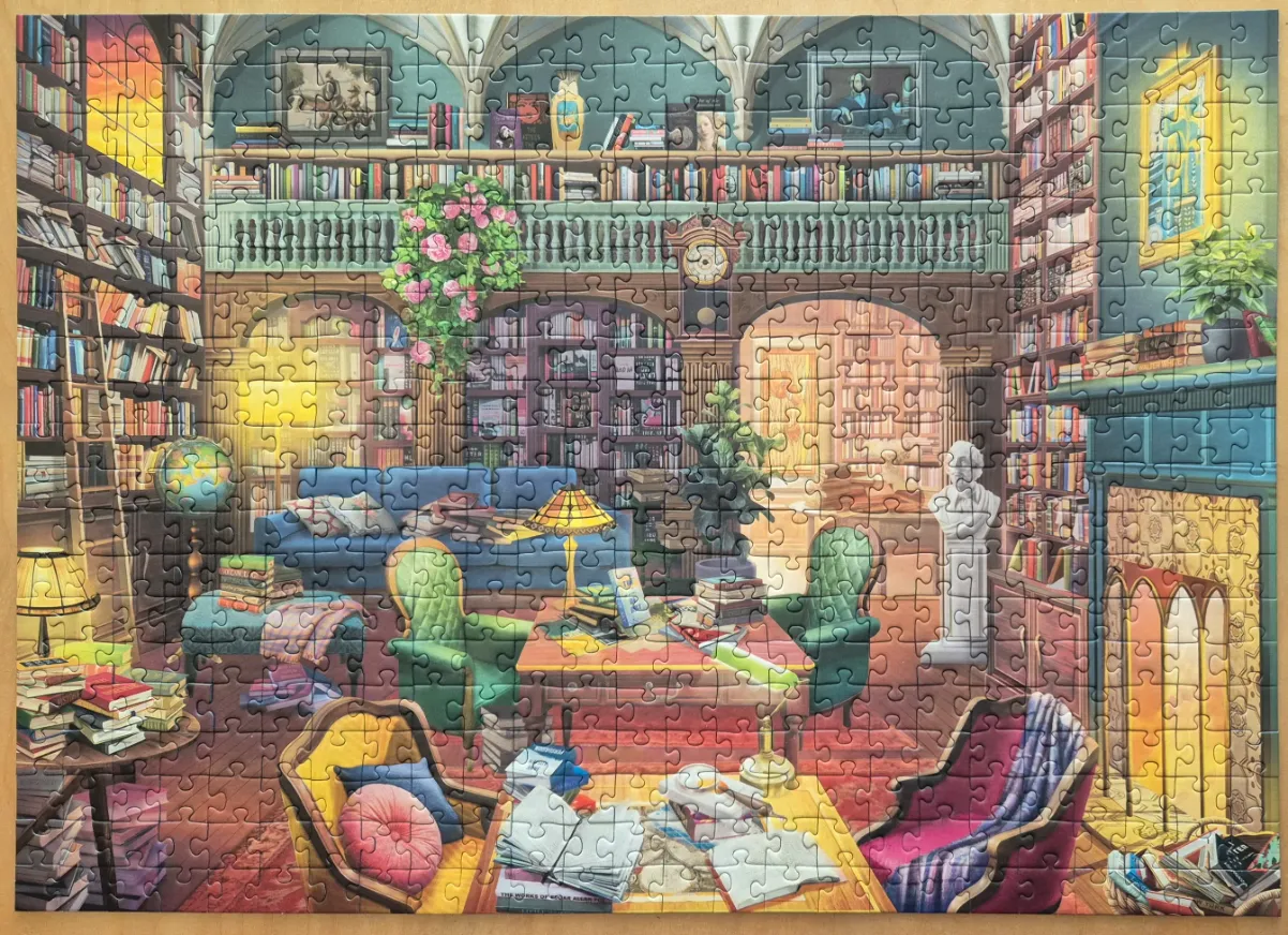 A cozy, sunlit personal library with bookshelves, plush armchairs, and a warm fireplace.