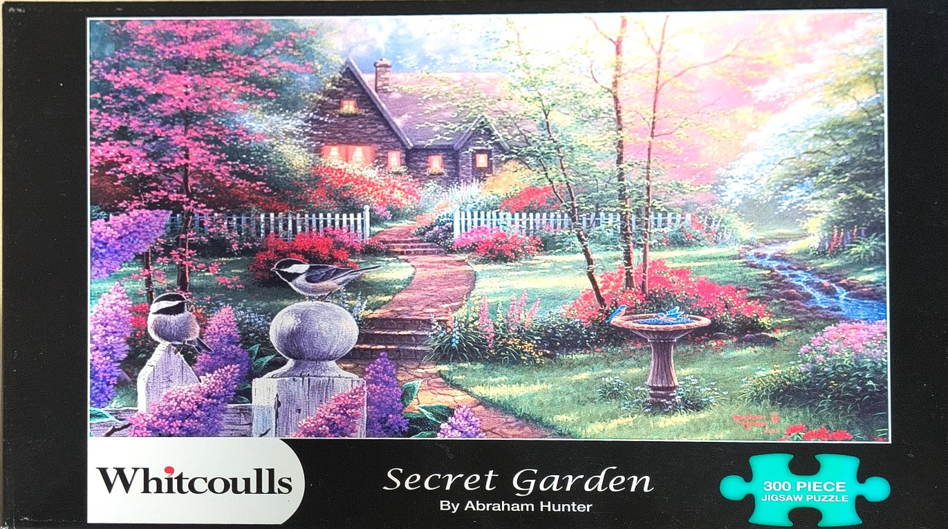 A peaceful garden scene with a stone cottage, a stone path, a birdbath, and two chickadees resting on a fence.