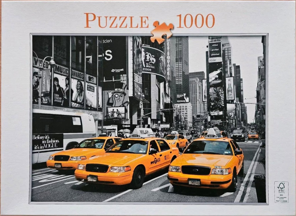 A black-and-white street scene of Times Square with three bright yellow taxis in the foreground.