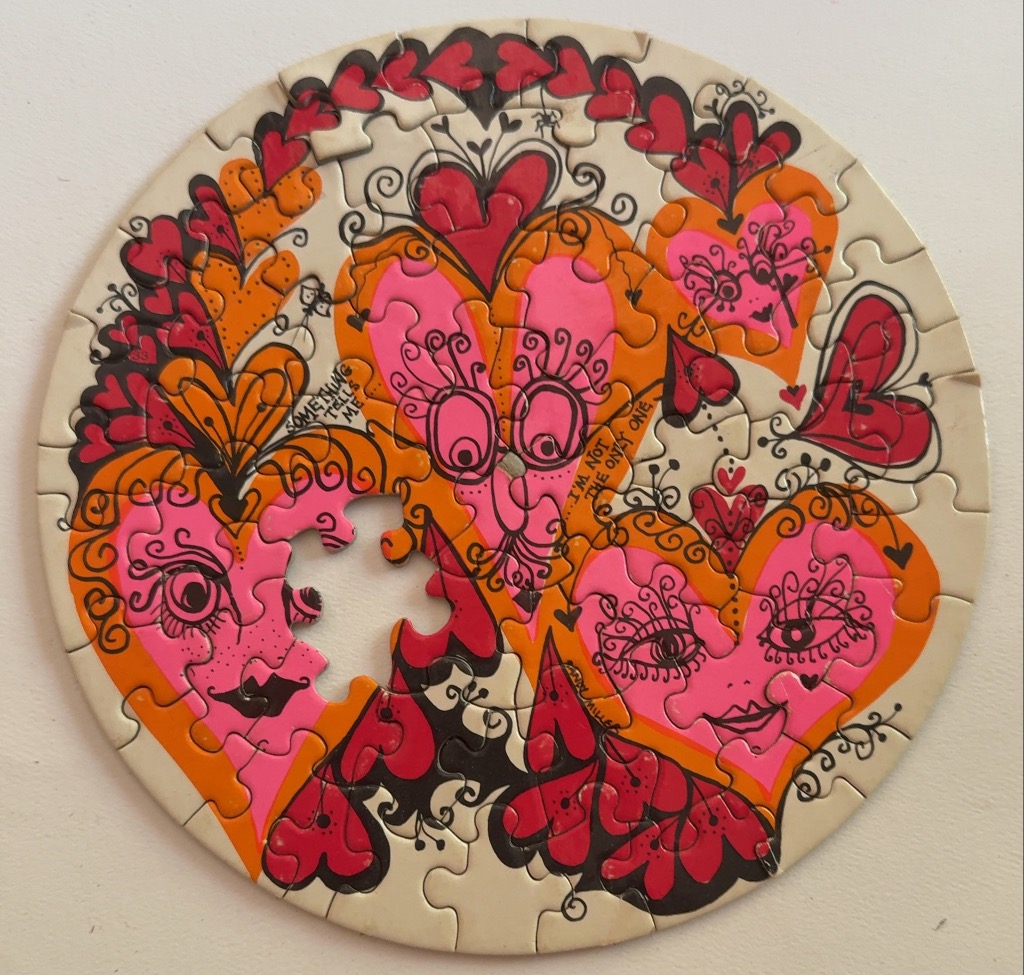 Round artwork featuring stylized hearts with whimsical faces and ornate line art in pink, orange, and red.