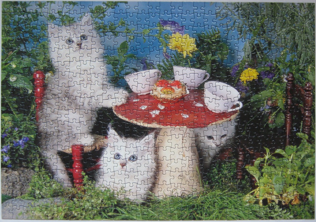 Three fluffy kittens gathered around a mushroom table in a lush garden setting.