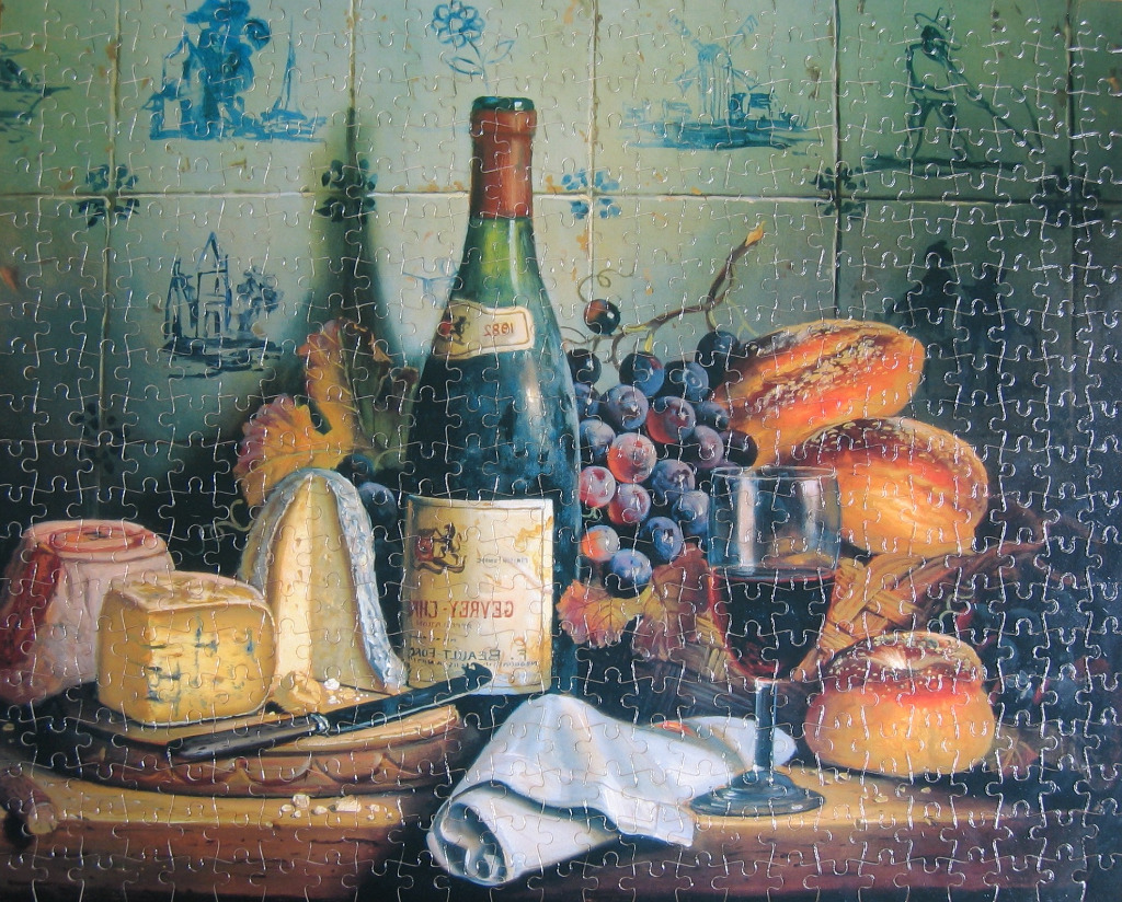 Still life painting featuring a wine bottle, grapes, cheese, and bread against a backdrop of blue and white Dutch tiles.