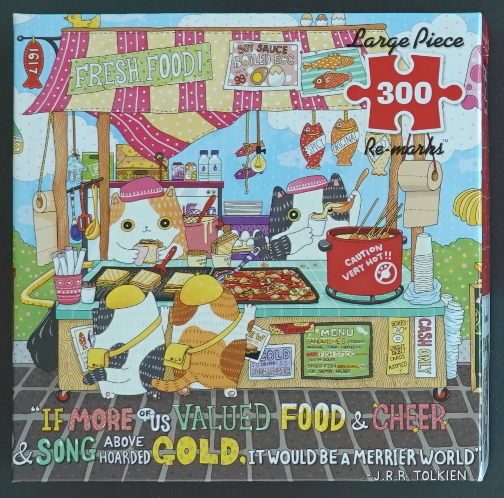 A whimsical cartoon illustration of cats running a street food stall with snacks, text signs, and a J.R.R. Tolkien quote.