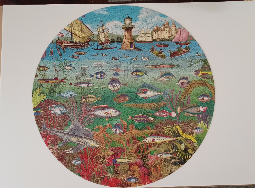 Circular illustration featuring a split-view of a sea surface with ships and a vibrant underwater coral reef ecosystem.
