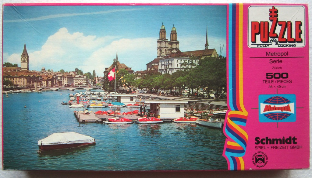 A scenic view of the Limmat River in Zurich with boats and the Grossmünster cathedral in the background.