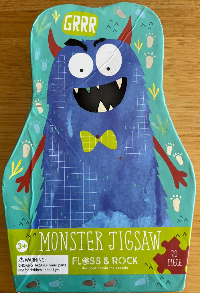 A whimsical blue monster character illustration on a uniquely shaped background.