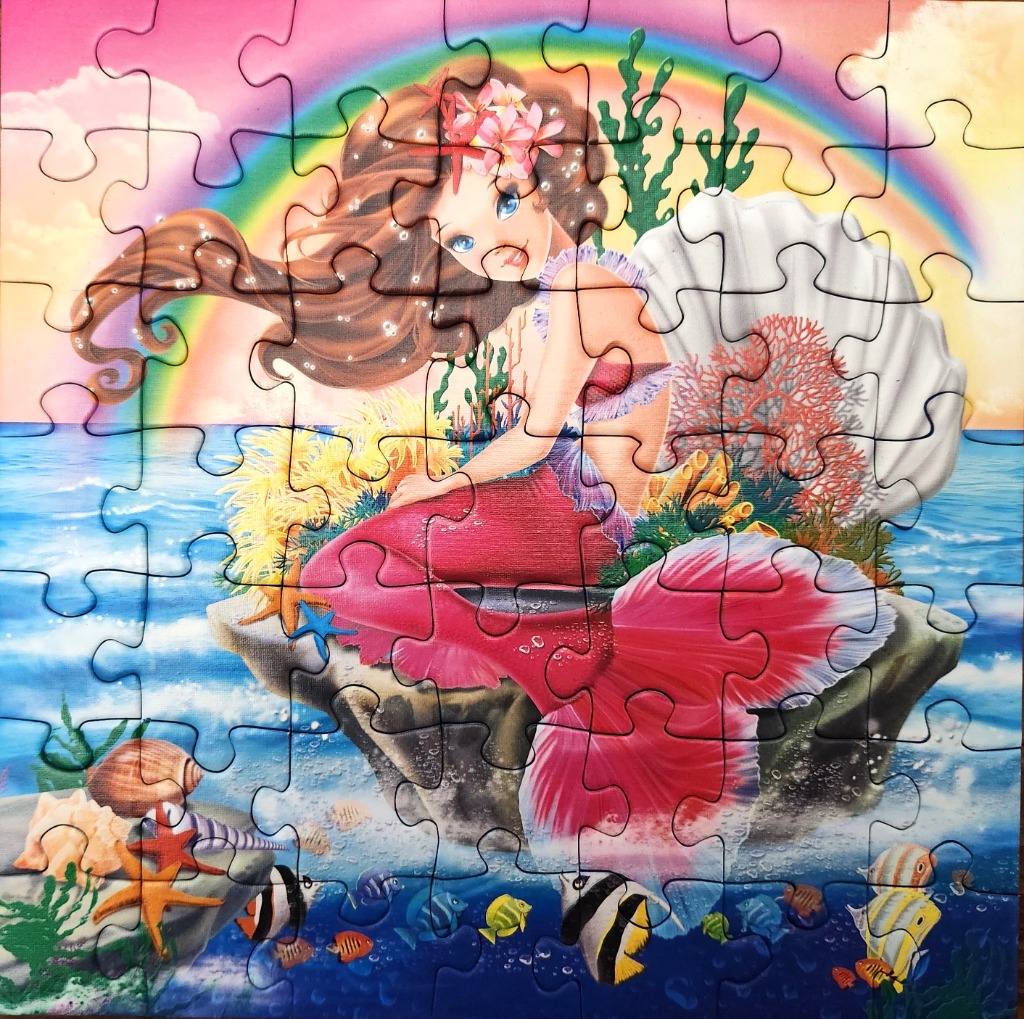 A whimsical illustration of a mermaid sitting on a rock in the ocean under a rainbow.