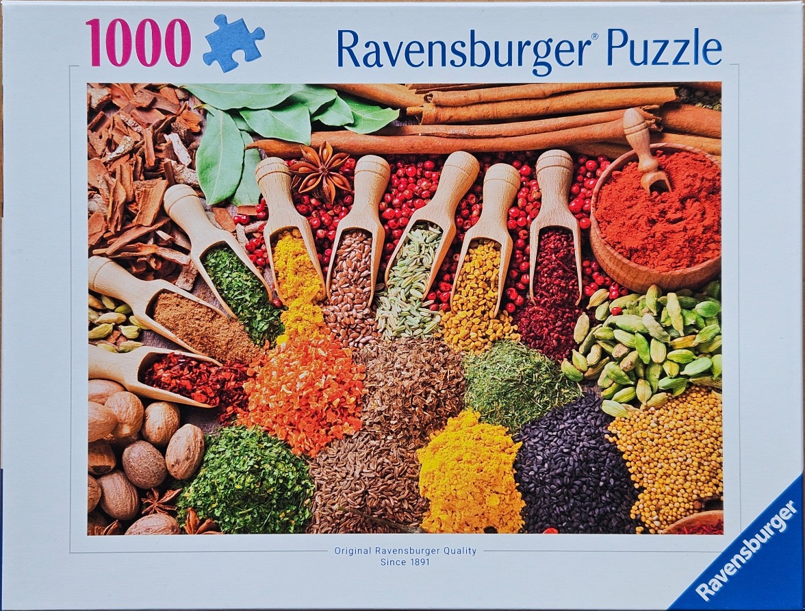 A top-down photographic close-up of various spices, herbs, and seasonings in wooden scoops and piles.