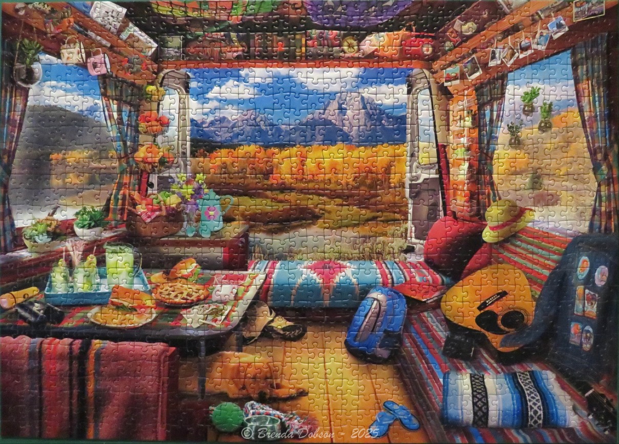 View from inside a cozy camper van looking out at a mountain landscape during autumn.