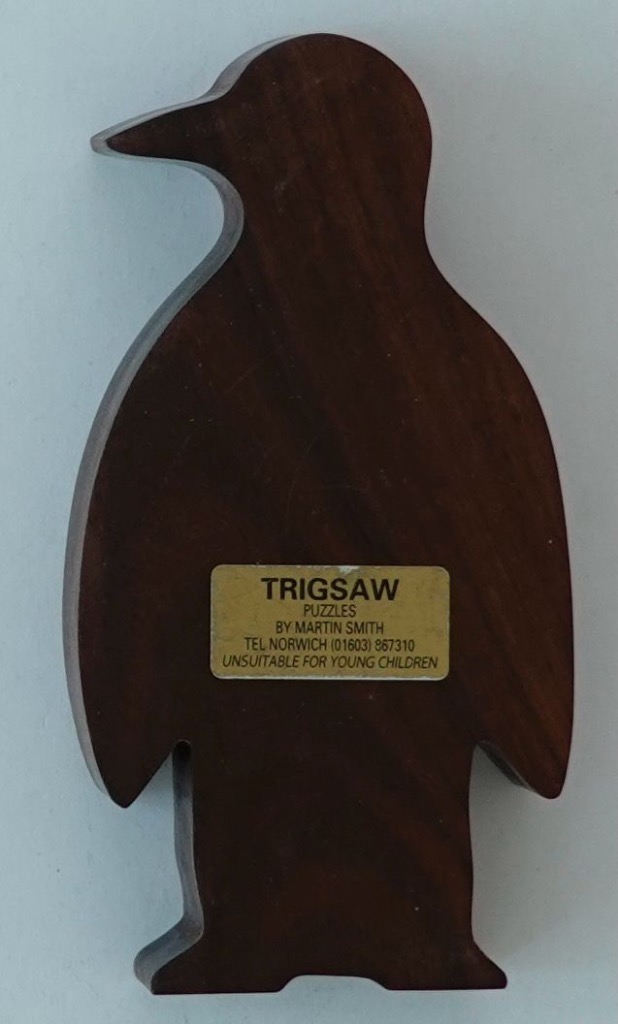 A smooth, dark wooden cutout in the shape of a standing penguin silhouette.