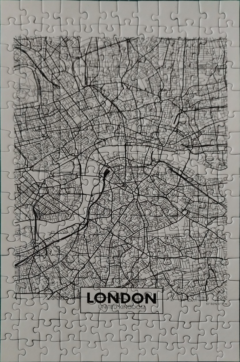 A black and white street map of London, England, featuring a prominent winding river and dense road networks.