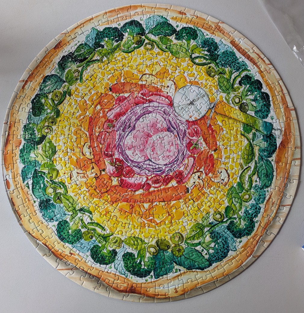 A circular illustration of a colorful vegetable pizza with broccoli, red onions, tomatoes, and carrots.