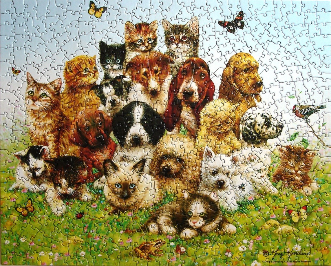 A group of diverse kittens and puppies clustered together in a grassy field with butterflies and a frog.