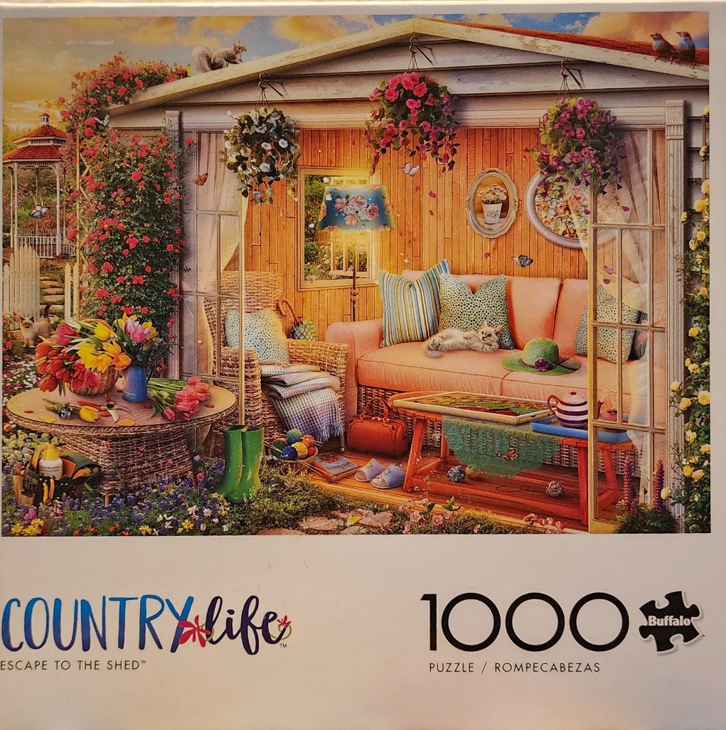 A cozy, flower-filled garden shed furnished with a sofa and armchair at sunset.