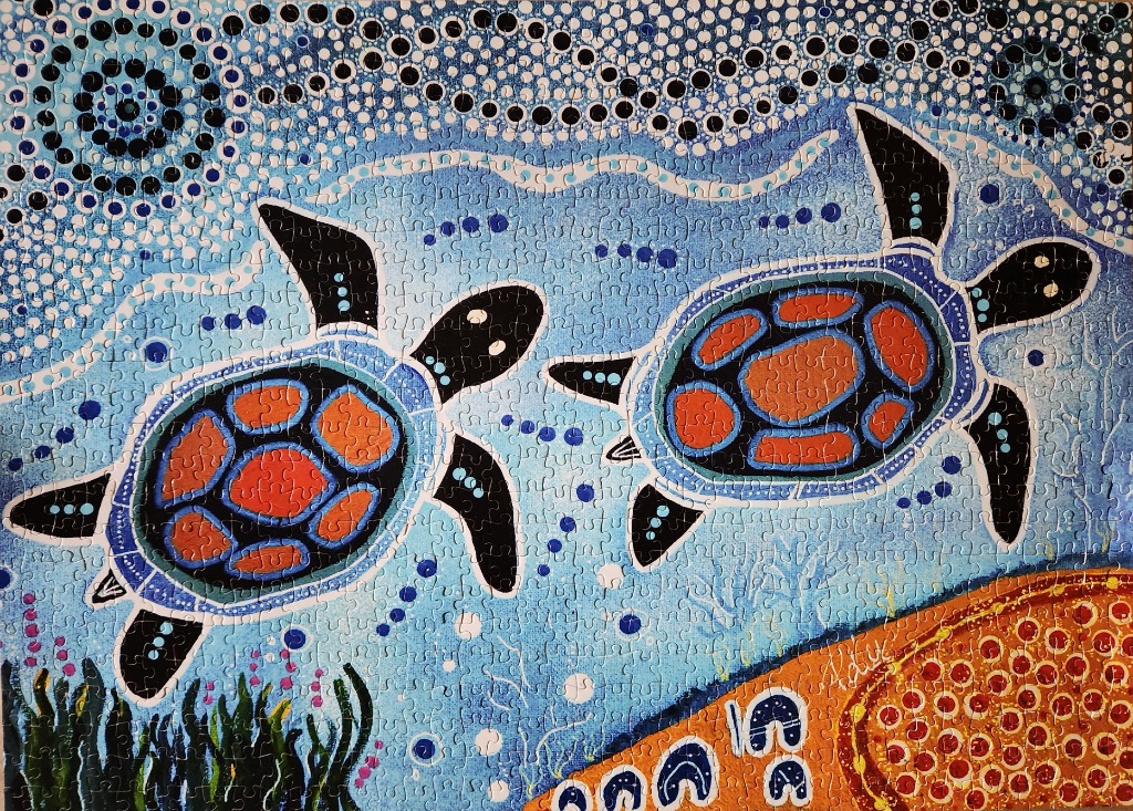 Indigenous-style dot painting of two sea turtles swimming in a blue ocean with a coral reef below.