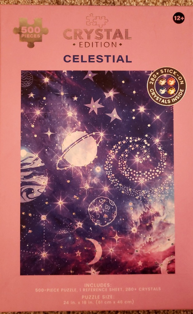 A celestial scene featuring planets, stars, and a galaxy in deep purple and pink hues, embellished with sparkling crystals.