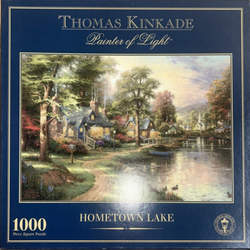 An idyllic landscape painting of a cottage by a lake with warm glowing lights and lush trees.