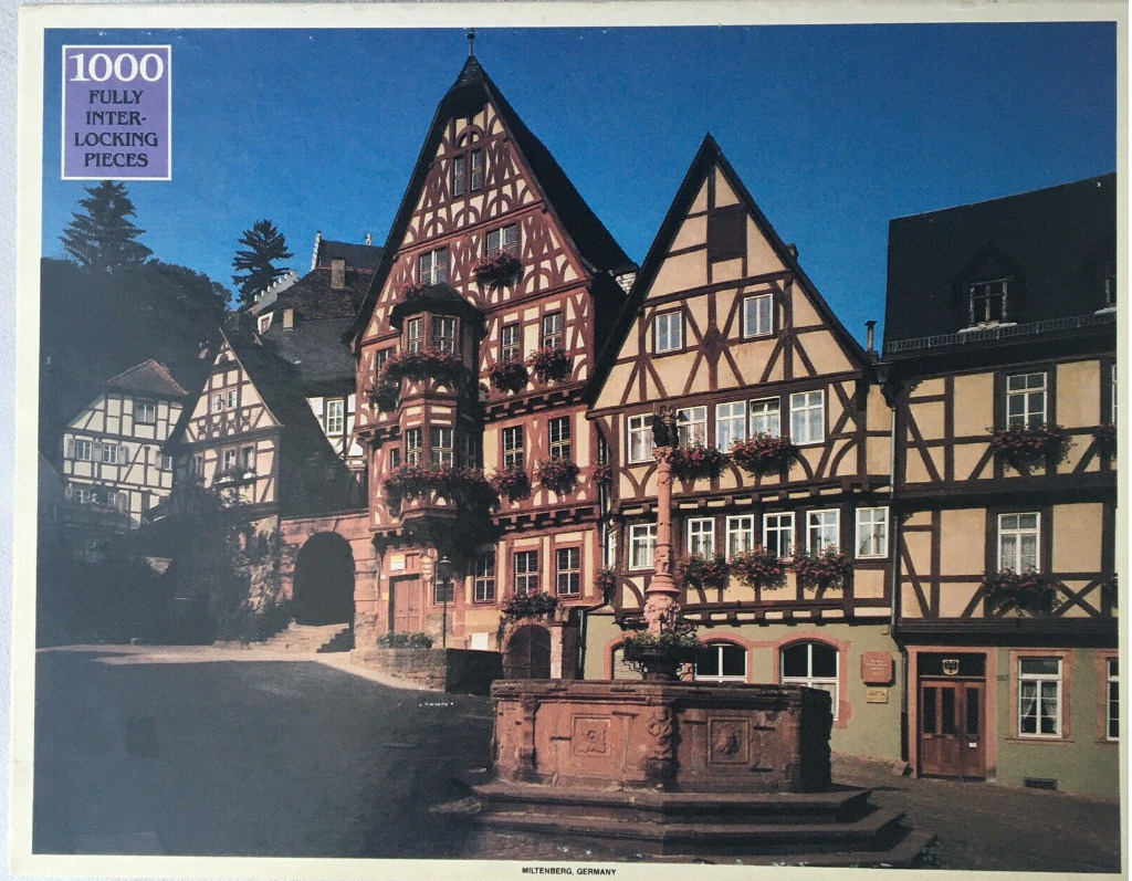 A sunny German market square with half-timbered houses and a stone fountain.