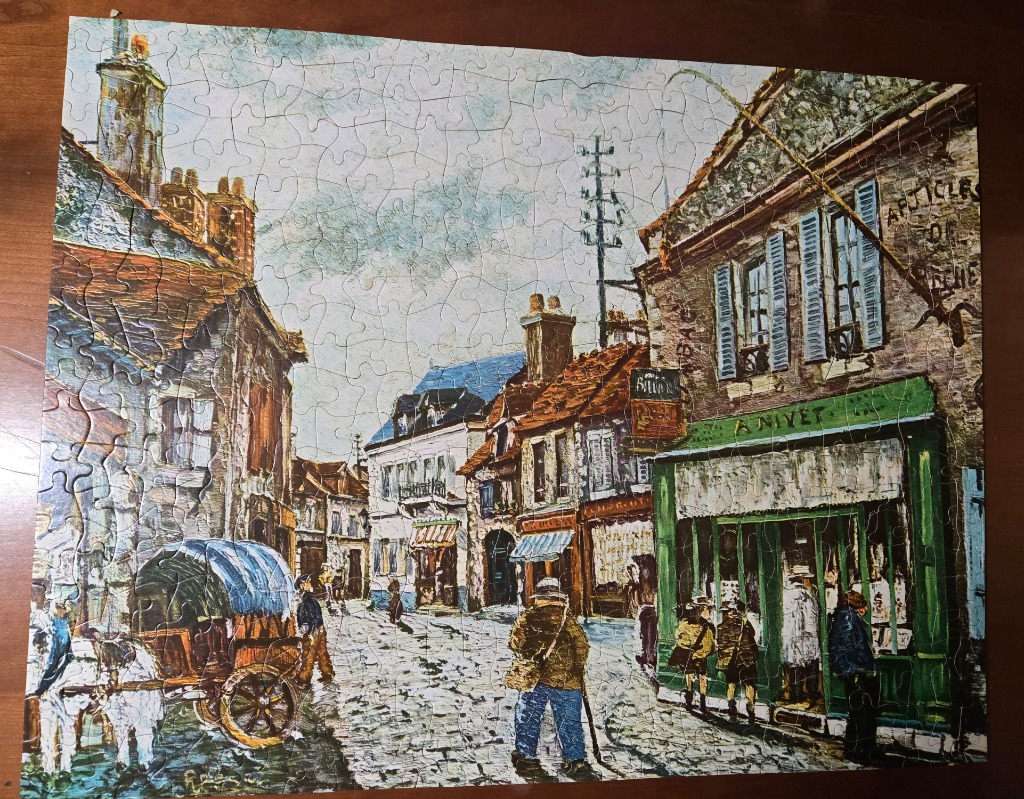 An Impressionist-style painting of a cobblestone street in a historic French town with a horse-drawn cart and shopfronts.