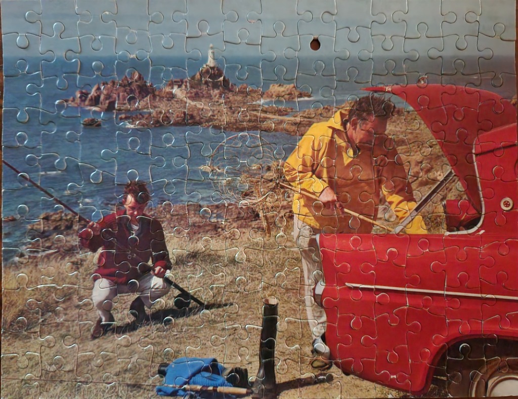 A man and a boy fishing by the sea near a bright red vintage car with a lighthouse in the background.