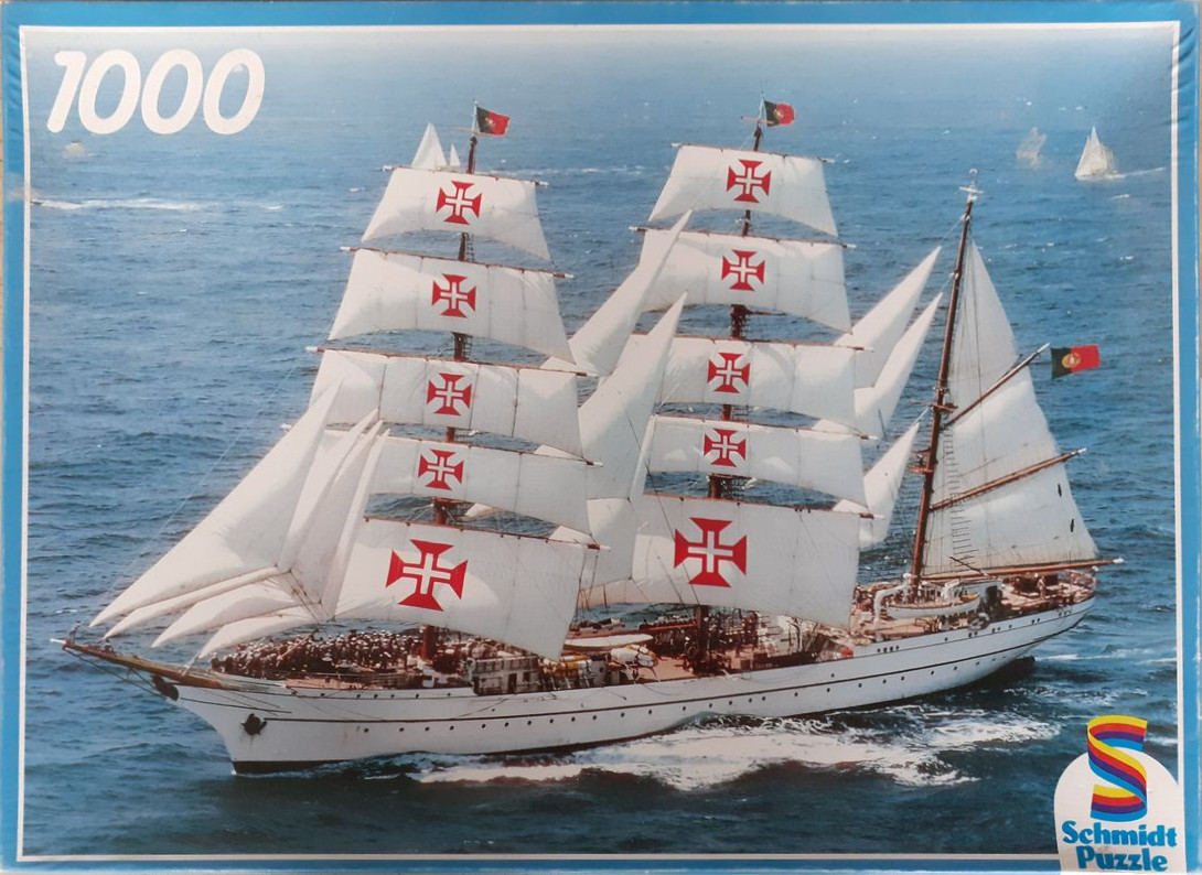A tall ship with sails featuring red crosses sailing on open blue ocean water.
