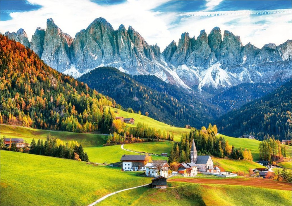 A village at the base of the dramatic, snow-dusted jagged peaks of the Dolomites in autumn.
