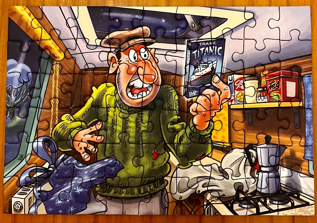 Cartoon of a man holding a Titanic DVD in a rustic room with a coffee maker.