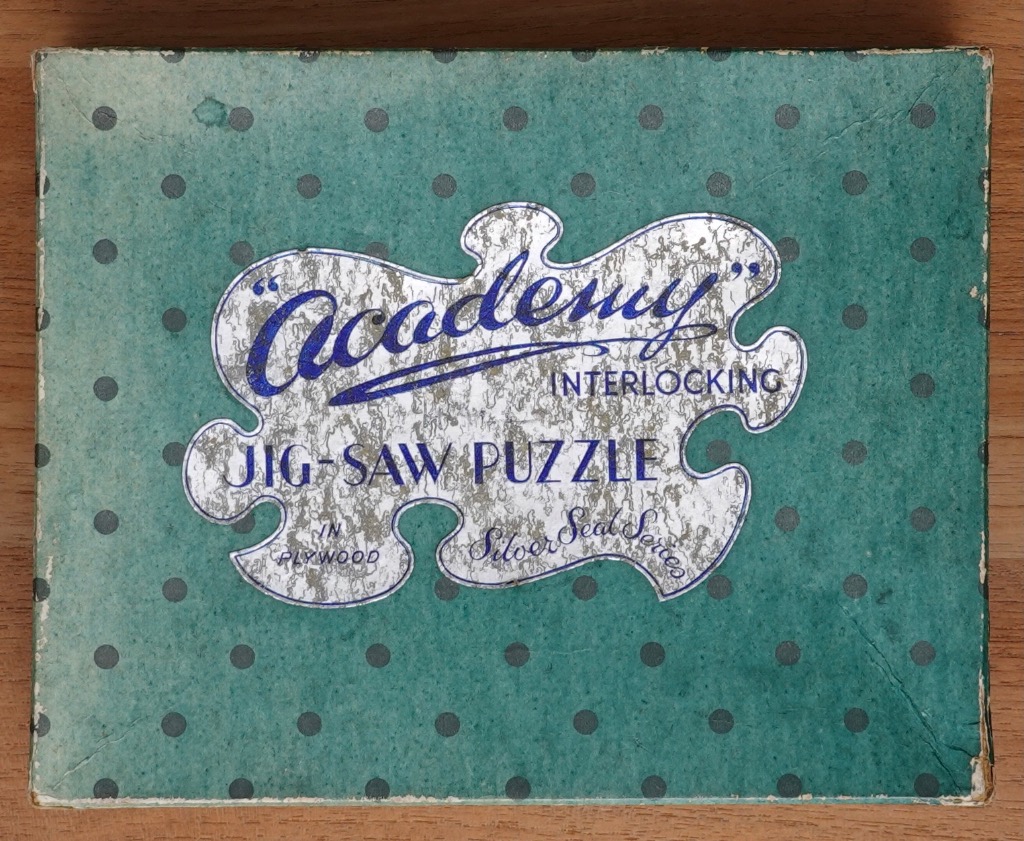 Vintage teal background with dark polka dots and a central stylized silver jigsaw piece shape featuring dark blue text.