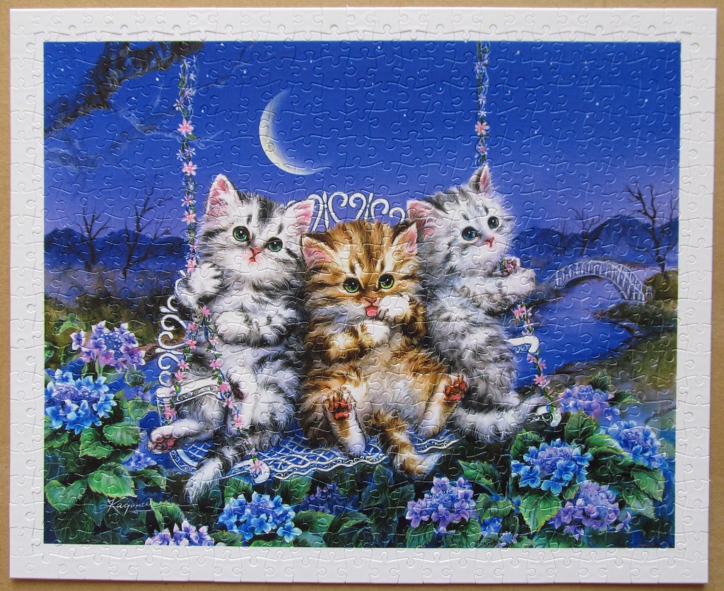 Three kittens sitting on a floral swing under a crescent moon in a night landscape.