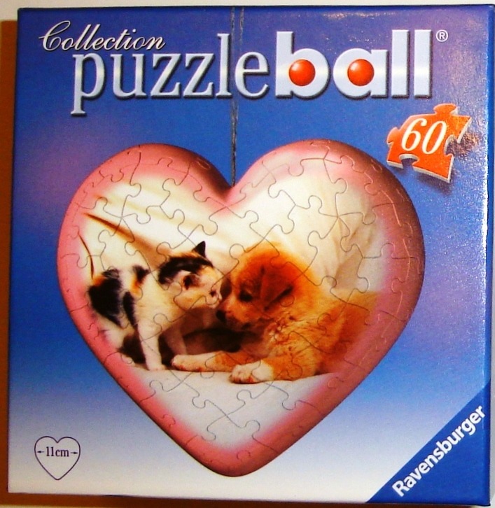 A kitten and a puppy sitting together inside a heart-shaped frame.