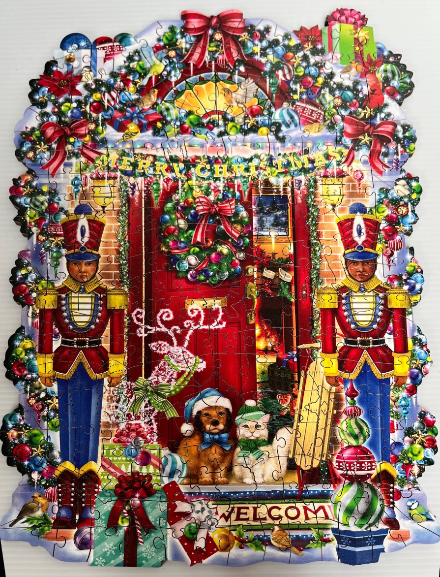 A whimsical Christmas scene with two toy soldiers flanking a red front door decorated with a wreath and festive items.