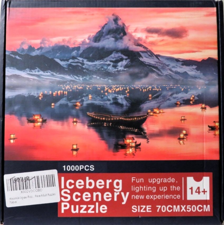 A mountain peak reflected in a lake filled with glowing lanterns at sunset.