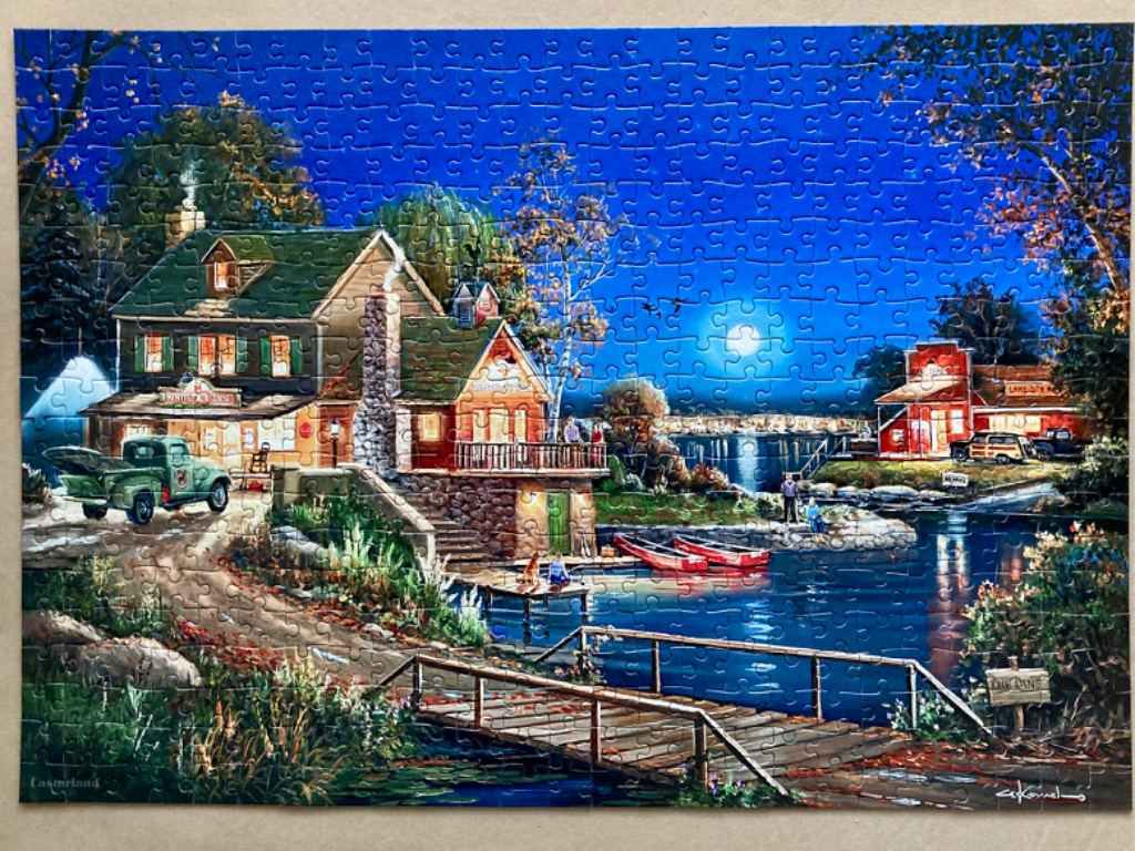 An idyllic lakeside scene at night with a house, a truck, and a dock under a full moon.