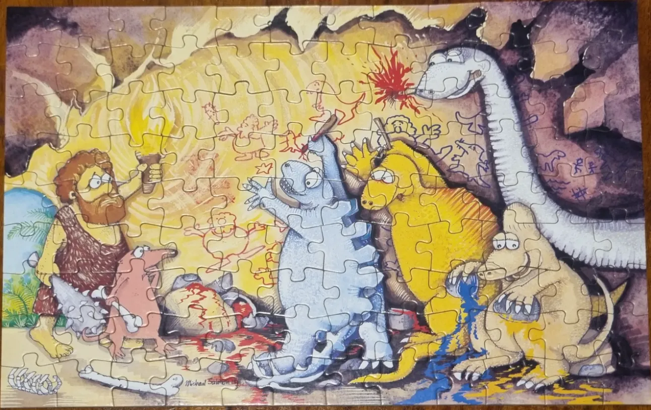 A cartoon illustration showing cavemen and dinosaurs painting on a cave wall together.