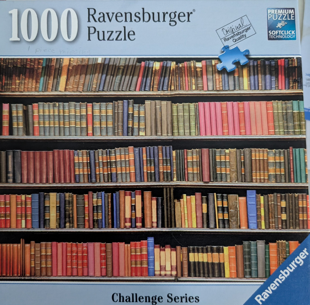A densely packed bookshelf with five shelves of varying hardcover books in a wide array of colours and sizes.